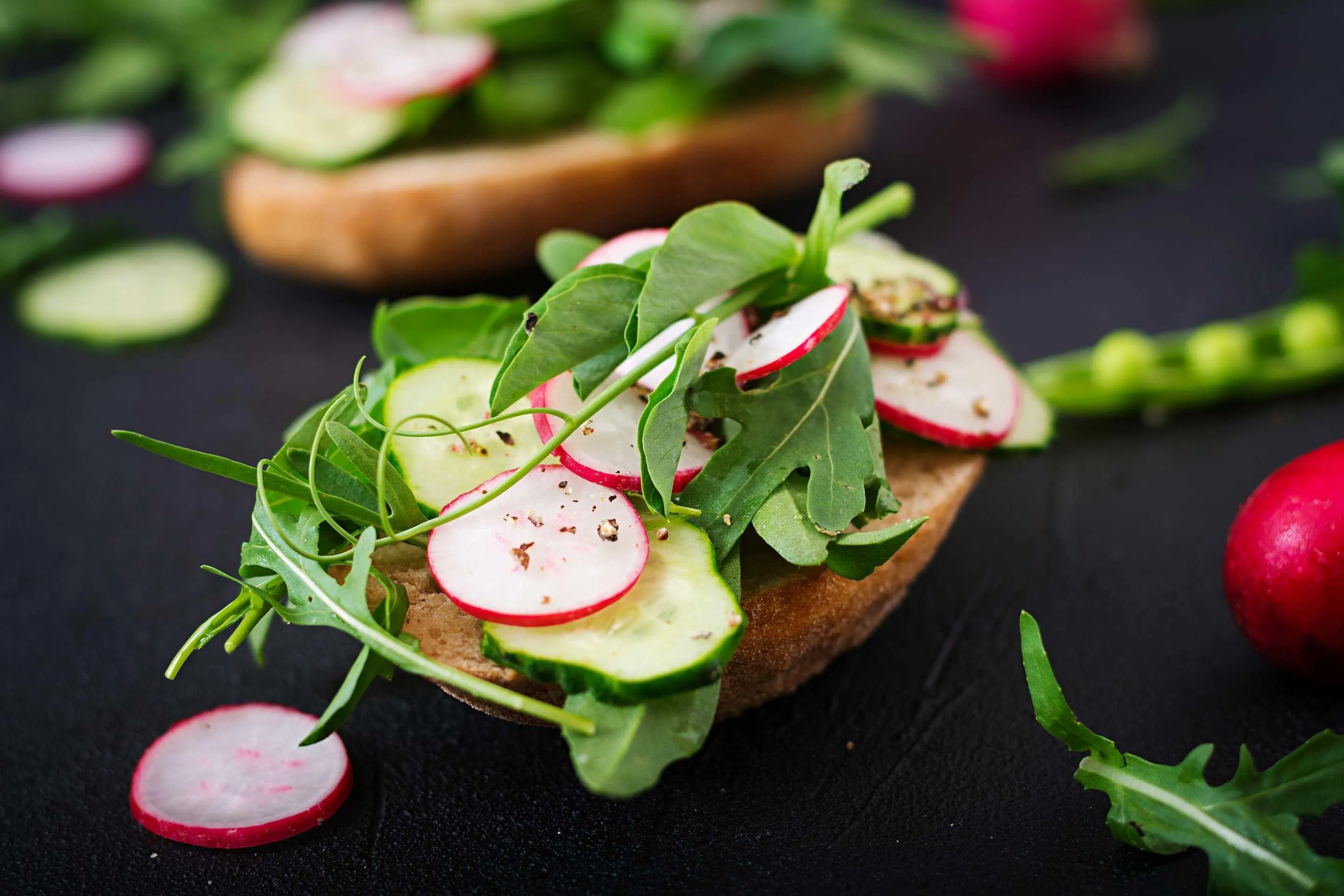 Fresh whole-food open sandwich with radish, cucumber, and greens